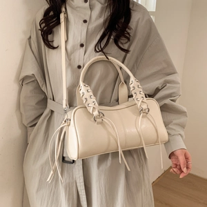 Détail du sac Boston crème avec poignée tressée, œillets et franges décoratives