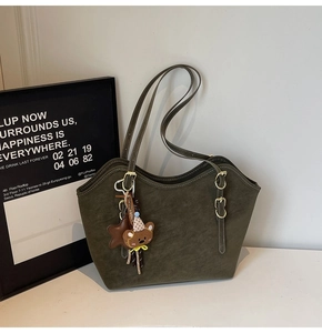 Detailed view of dark olive green tote bag with metal buckles and cute star charm
