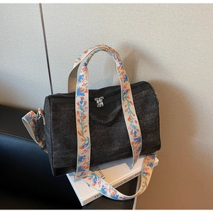 Detail of Boston bag with colorful abstract patterned strap and leather logo patch