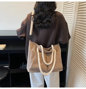 Detailed texture of corduroy tote bag with white rope handles and dual front pockets