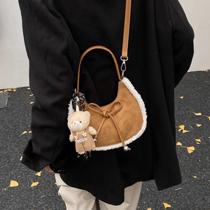 Sac hobo en daim marron avec bordure en fourrure et nœud dans un décor d'automne