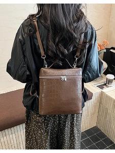 Close-up of brown crocodile pattern PU leather backpack worn on model's back
