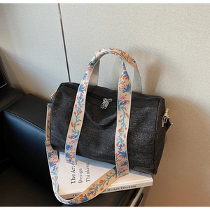 Detail of dark grey tote bag with colorful floral embroidery on the wide shoulder strap