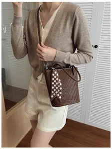 Détail du sac seau marron tressé avec foulard à pois sur une vue de l'épaule