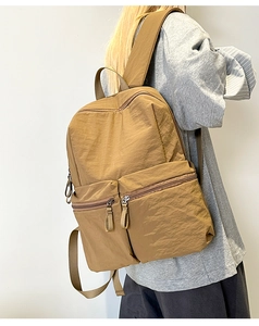 Detail view of khaki large capacity backpack with waterproof nylon fabric on model