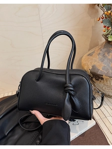 Dettaglio borsa a mano in pelle martellata nera con manico a nodo e tracolla regolabile chic