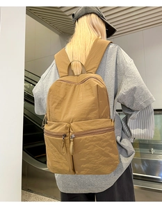 Rear view of Earth-toned large nylon backpack featuring multiple front zipper pockets