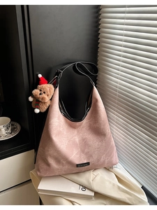 Gros plan d'un sac seau rose avec texture vintage et breloque en peluche petit ours