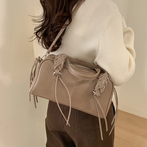 Détail du sac Boston en cuir kaki avec glands latéraux et accents d'œillets métalliques