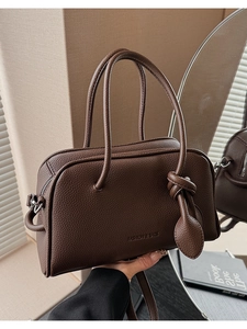 Dettaglio della borsa Boston marrone scuro con grana litchi e logo in rilievo