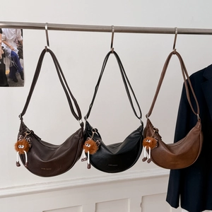 Trois sacs à bandoulière demi-lune en cuir noir et marron avec pendentifs en peluche