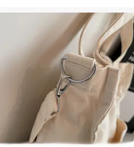 Close-up of durable canvas fabric and high-quality silver lobster clasp on a shoulder bag