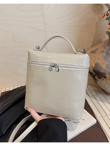 Close-up of cream white crocodile-embossed tote bag with elegant silver hardware