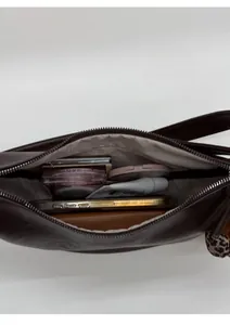 Vue intérieure du grand sac bandoulière marron foncé montrant l'espace de rangement
