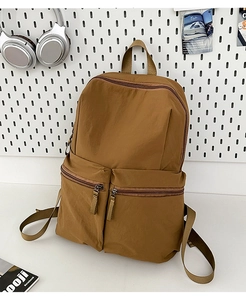 Detail of water-resistant nylon backpack with two front zipper pockets in brown