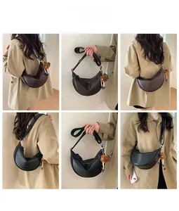 Détail du grand sac bandoulière en demi-lune avec breloque peluche sur un mannequin