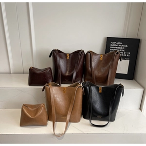 Detail view of large leather bucket bags in four colors with gold metal locks