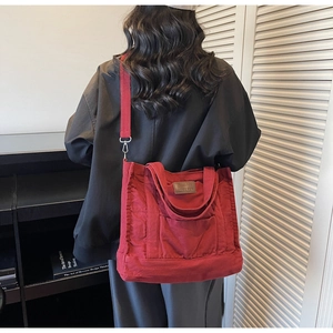 Detailed view of the large burgundy canvas tote bag with adjustable shoulder strap