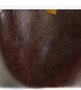 Detail of dark reddish-brown leather bucket bag featuring luxury lychee grain texture