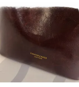 Close-up of vintage dark brown oil-wax leather texture with gold Fashion & Bags lettering