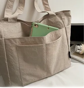 Geräumige beige Tragetasche mit mehreren Außentaschen und großem Stauraum für den Alltag