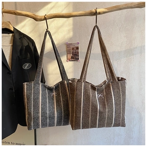 Detail of vintage striped tote bags with bow embroidery hanging on artistic branches