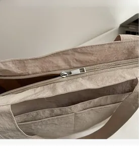 Detail des glatten Metallreißverschlusses und der Innentaschen an der khakifarbenen Tasche