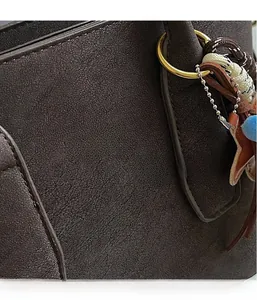 Macro detail of dark brown frosted leather texture with golden Vanzza Hanog logo