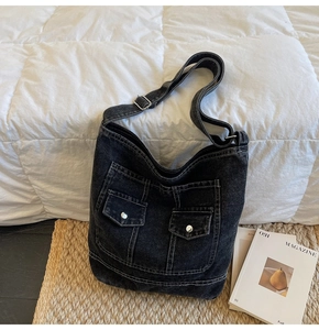 Close-up of vintage grey denim tote bag showing cargo pockets and contrast stitching