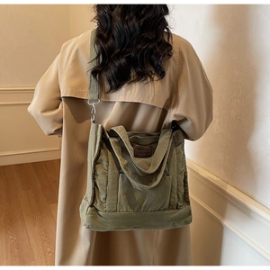 Army green canvas tote bag detail showing the leather brand label and large capacity