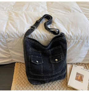 Detail of black washed denim tote bag featuring white contrast stitching and cargo pockets