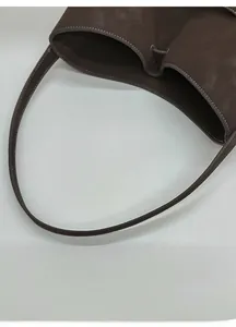 Détail du sac cabas en daim marron foncé avec coutures contrastées et anses robustes