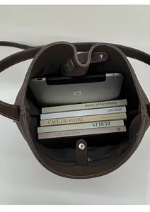 Vue de haut de l'intérieur du sac seau marron montrant sa grande capacité et ses coutures