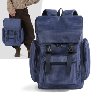 Detail of dark blue checkered backpack showing buckles, side pockets and durable fabric