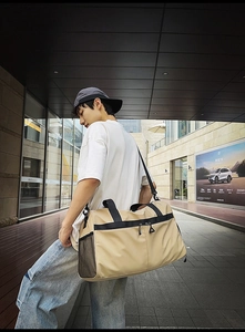 Detalle de bolsa de deporte caqui con bolsillo lateral de malla y correa resistente