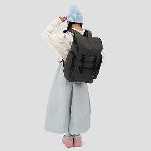 Detail of checkered backpack featuring buckle straps and side pocket for daily travel