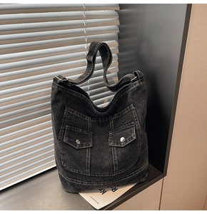 Close-up of vintage washed denim tote bag with cargo pockets and contrast stitching