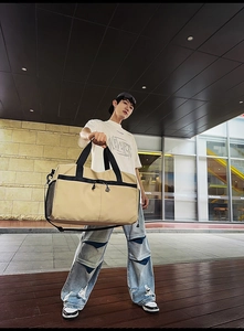Bolsa de viaje fitness grande color caqui con asas negras mostrada por un modelo