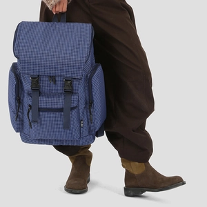 Detail view of the blue checkered backpack featuring durable plastic buckles and side pockets