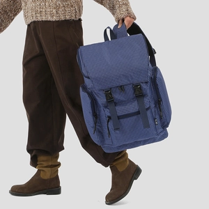 Detailed shot of blue checkered backpack with side zipper pocket and buckle straps