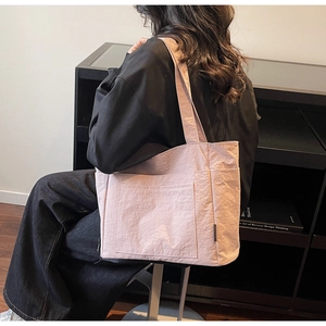 Detailansicht der hellrosa Nylon-Tragetasche mit Knitteroptik an der Schulter