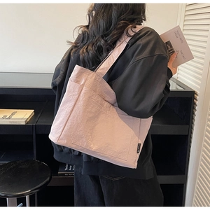 Detailaufnahme der rosa plissierten Nylon-Einkaufstasche mit Fronttasche und Markenetikett