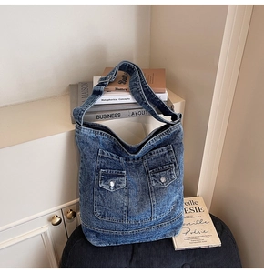 Detailed view of retro washed denim tote bag featuring dual front metal buckle pockets