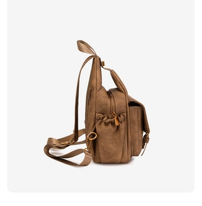 Detail view of brown soft PU leather backpack with side pockets and golden zippers