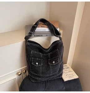Detail of washed black denim tote with adjustable silver buckle strap and cargo pockets