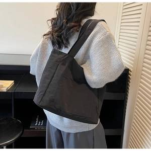 Seitenansicht einer großen schwarzen Canvas-Tasche für Damen im lässigen Pendler-Stil