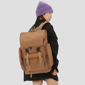 Detail of grid pattern backpack featuring side zipper pockets and adjustable buckle straps