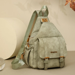 Detail of sage green matte faux leather chest bag with golden hardware and logo