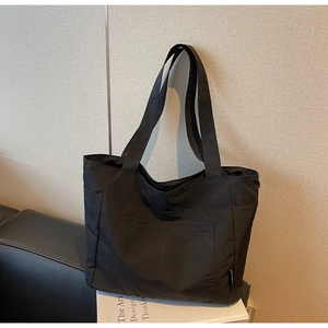 Detail einer schwarzen Nylon-Einkaufstasche mit mehreren Taschen und breiten Riemen