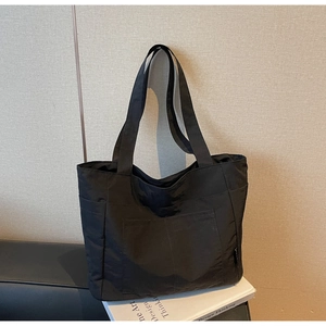 Praktische große schwarze Nylon-Tragetasche mit Vordertaschen auf Designbüchern